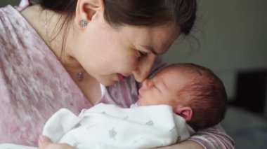 Anne kucağında yeni doğmuş bir bebekle. Yakın plan. Anneliğin ve aşkın mutluluğu