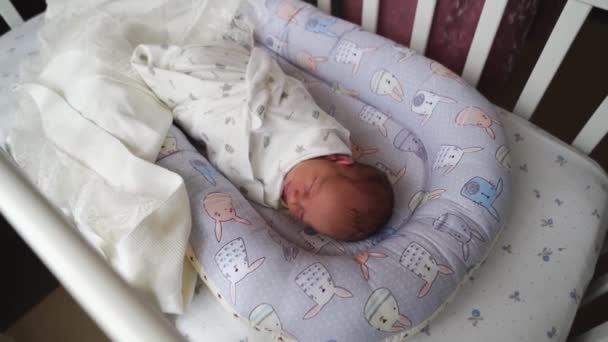 엄마들 이 갓난아기의 요람에서 잠 자고 있는 아기 의침 대에서 담요를 똑바로 펴고 있다. — 비디오