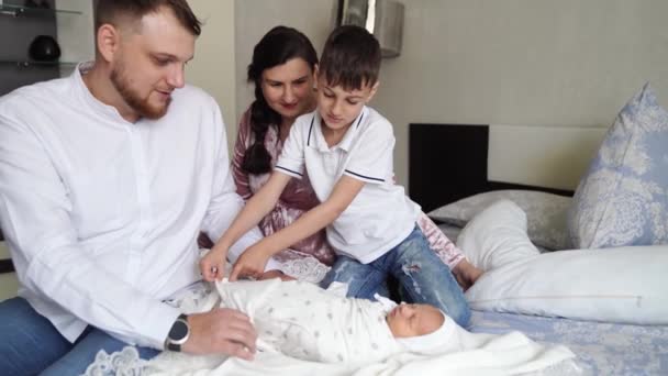 Первый день новорожденного дома. Счастливая семья с малышом в спальне — стоковое видео