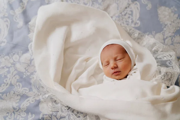 Το νεογέννητο μωρό κοιμάται με άσπρα ρούχα. ενδυμασία για εξιτήριο από το νοσοκομείο. — Φωτογραφία Αρχείου