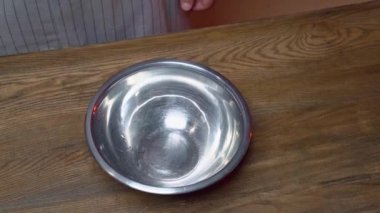 Yukarıdan bak. Metal bir kaseye cam sürahiden su dök.. 