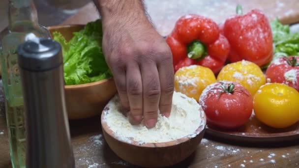 Mani uomo prendere la farina da una ciotola e battere le mani. disperdere la farina — Video Stock