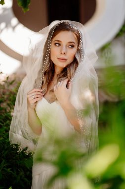 Bahçede uzun dalgalı saçlı gelin. Düğün makyajı.. 