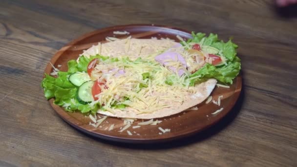 Male hands swerve pita with vegetables and cheese. vegetarian roll. — Stock Video