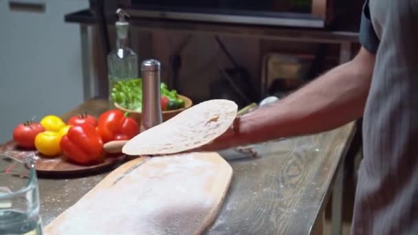 Un hombre arroja un pan plano y la harina se dispersa. tras bastidores. — Vídeo de stock