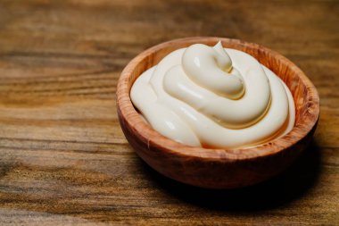 Beyaz sos. Mutfak masasında mayonez olan küçük tahta kase.. 