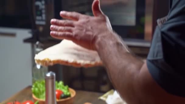 Egy férfi tenyérrel a kezén lapos kenyeret dob. színfalak mögött. — Stock videók
