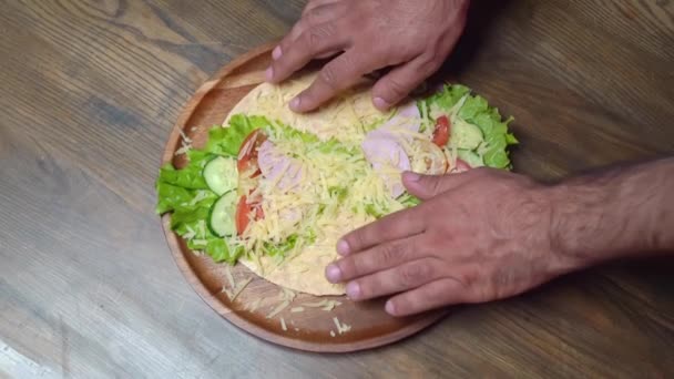Pánské ruce vaří pitu se zeleninou a sýrem. vegetariánská role. — Stock video
