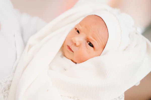 Recién nacido en ropa blanca en las manos de los padres. vestimenta para el alta del hospital — Foto de Stock