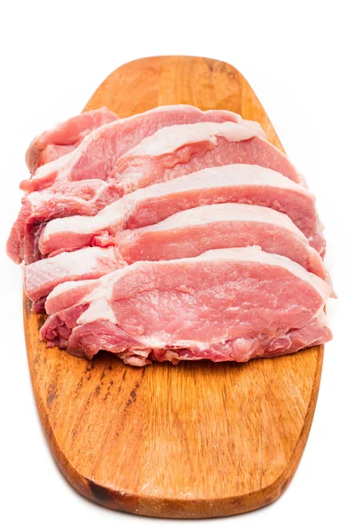 Picado en trozos de cerdo crudo en una tabla de cortar de madera sobre un fondo blanco. —  Fotos de Stock
