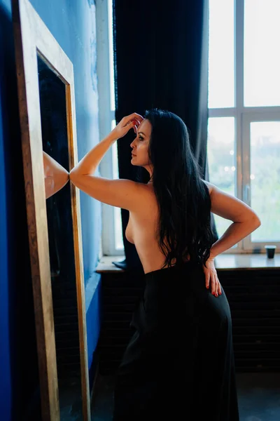 Γυμνόστηθη. Όμορφη και σέξι γυναίκα με γυμνό στήθος και μακριά μαλλιά στον καθρέφτη. — Φωτογραφία Αρχείου