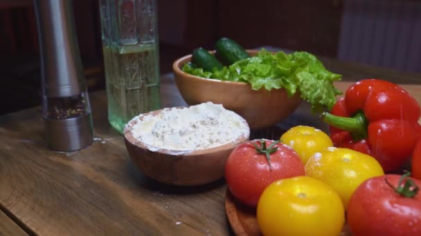 Hand takes flour from a wooden bowl and sprinkle a little through his fingers. — Stock Video