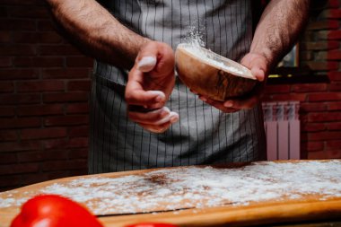 Elinde un olan ahşap kaseli önlüklü bir adam.