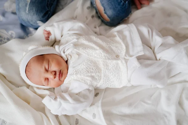 El bebé recién nacido duerme con ropa blanca. vestimenta para el alta del hospital. — Foto de Stock