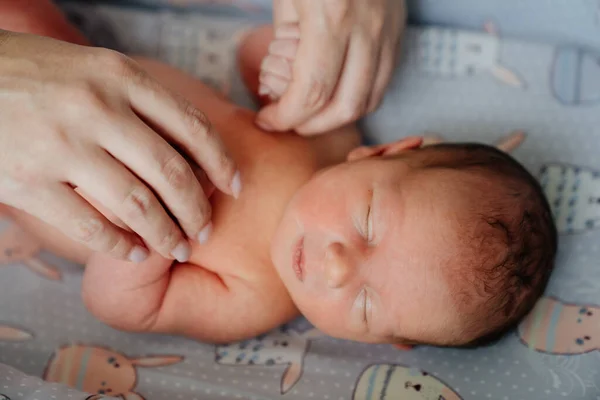 Mamá cogida de la mano del recién nacido. los niños duermen. cosméticos para el cuidado de la piel —  Fotos de Stock