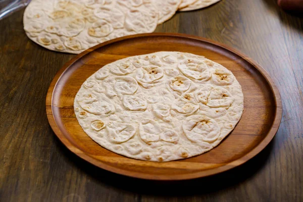 Fladenbrot Fladenbrot auf einem runden Holzschneidebrett. Bäckerei. Fladenbrot — Stockfoto