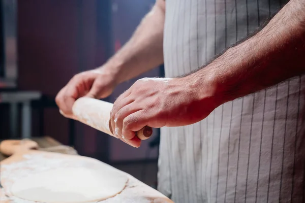 Händerna rullar degen i ett tunt lager. Matlagning pizza, nudlar eller pitta hemma — Stockfoto