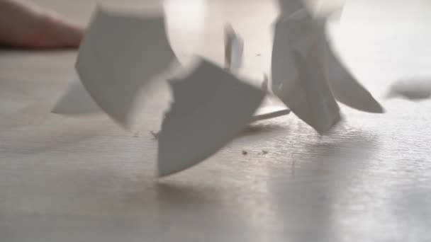 흰 판 이 바닥에 떨어져 부서지는 모습. — 비디오