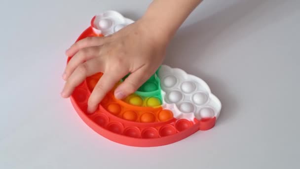 Tangan bermain dengan multi-warna anti-stres mainan dalam bentuk pelangi. — Stok Video