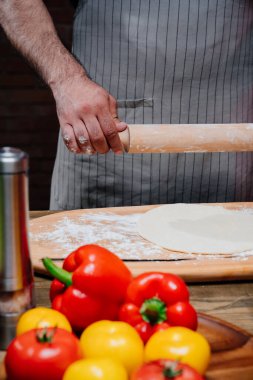 Eller hamuru ince bir tabakaya sarar. Evde pizza, erişte ya da pitta pişiriyorum.