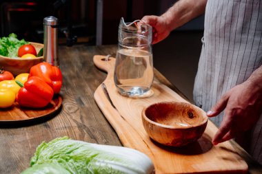 Aşçı önlüklü bir adam mutfaktaki masada duruyor. yemek programı