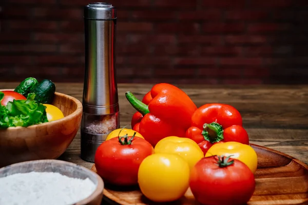 Un tazón de madera de harina, especias y verduras en la mesa de la cocina — Foto de Stock