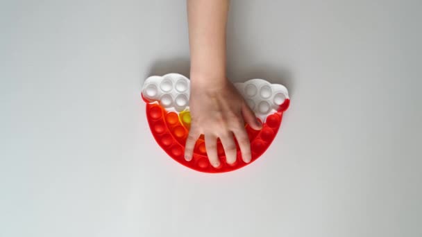 Handspiele mit einem bunten Anti-Stress-Spielzeug in Form eines Regenbogens. — Stockvideo