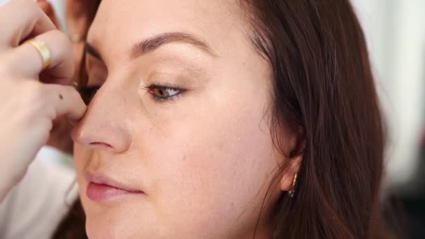 As mulheres fazem maquiagem, pintam as pestanas com rímel e pestanas falsas — Vídeo de Stock