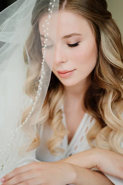 the brides morning. a beautiful young woman with long hair under the veil