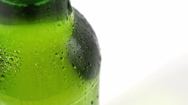 Kapat. Damlalar şişenin soğuk yeşil camından aşağı akar. yoğunlaştır