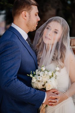 Peçenin altındaki nazik gelin ve damat. Güzel ve romantik yeni evliler.. 