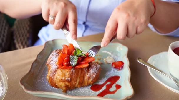 拍手特写。女人吃带有草莓、薄荷和果酱的羊角面包 — 图库视频影像