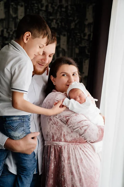 Familia feliz con un niño pequeño en el dormitorio junto a la ventana. —  Fotos de Stock