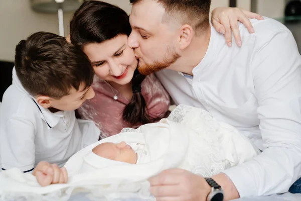 Den första dagen av den nyfödda hemma. Lycklig familj med ett litet barn i sovrummet — Stockfoto