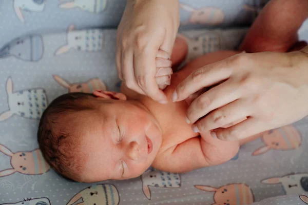 Mamá cogida de la mano del recién nacido. los niños duermen. cosméticos para el cuidado de la piel —  Fotos de Stock