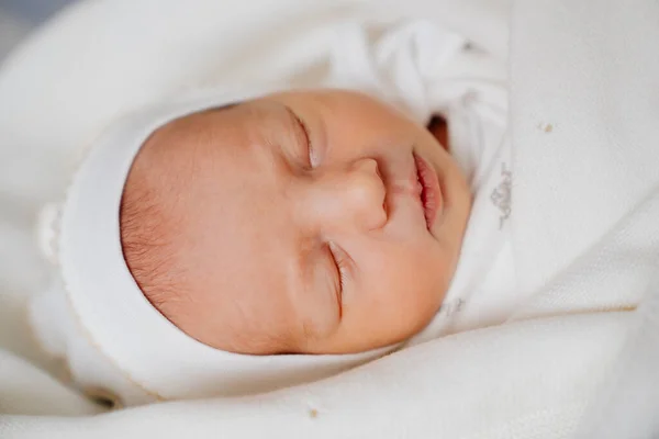 Söt nyfödd bebis sover i vita kläder. klädsel för utskrivning från sjukhus. — Stockfoto