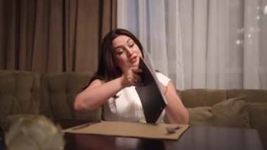 Bir kadın menüyü okuyor ve restoranda yemek siparişi veriyor. Yiyecek seçenekleri.