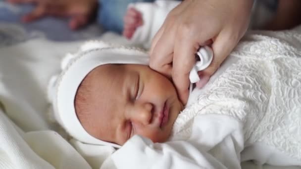 Το νεογέννητο μωρό κοιμάται με άσπρα ρούχα. ενδυμασία για εξιτήριο από το νοσοκομείο. — Αρχείο Βίντεο