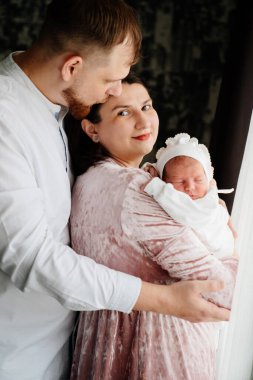 Kollarında bebek olan mutlu bir çift. Hastaneden taburcu oldum. Evdeki ilk günüm.