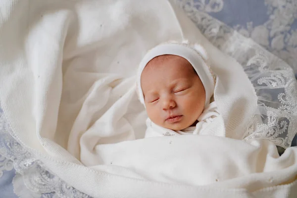 pretty Newborn baby sleeps in white clothes. attire for discharge from hospital.