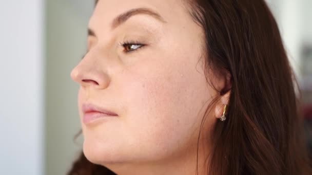 Kvinnor gör make-up, måla sina ögonfransar med mascara och lösögonfransar — Stockvideo