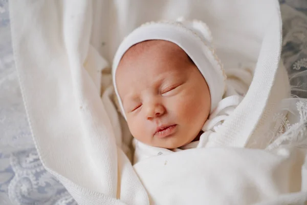 pretty Newborn baby sleeps in white clothes. attire for discharge from hospital.