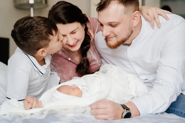 Den första dagen av den nyfödda hemma. Lycklig familj med ett litet barn i sovrummet — Stockfoto