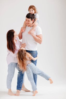 Beyaz bir fotoğraf stüdyosunda güzel, mutlu bir aile. veli-çocuk ilişkisi