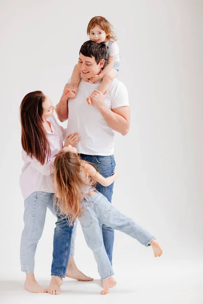 Schöne glückliche Familie in einem weißen Fotostudio. Eltern-Kind-Beziehung — Stockfoto