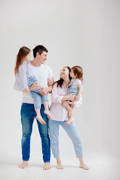 Belle famille heureuse lors d'une séance photo dans un studio photo blanc. dans les coulisses. — Photo