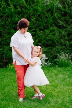 Bahçede küçük bir kızı olan yaşlı bir anne. Geç gebelik ve doğum.