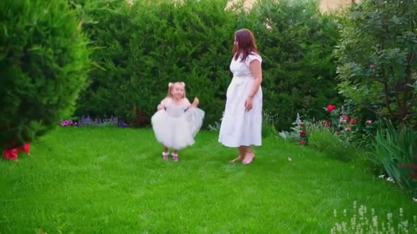 Mamá, abuela e hija se divierten y juegan en el césped en el patio trasero — Vídeos de Stock