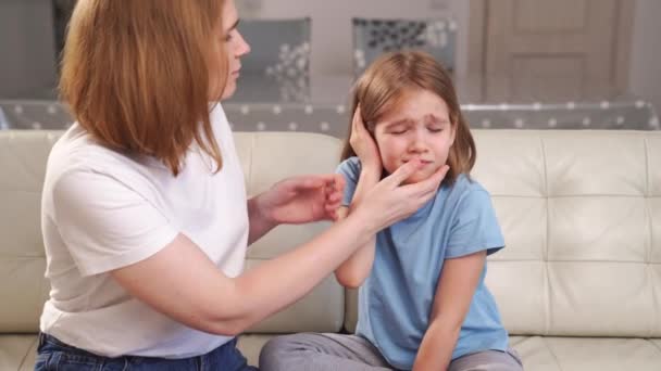 Ein Mädchen klagt über Schmerzen im Ohr und wird von ihrer Mutter untersucht. Kinderkrankheiten. — Stockvideo