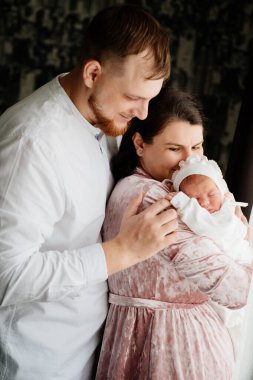 Kollarında bebek olan mutlu bir çift. Hastaneden taburcu oldum. Evdeki ilk günüm.